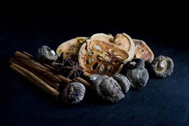 Kuru bael meyve çayı ve mantar, tarçın, siyah arka plan üzerine izole Yıldız anason