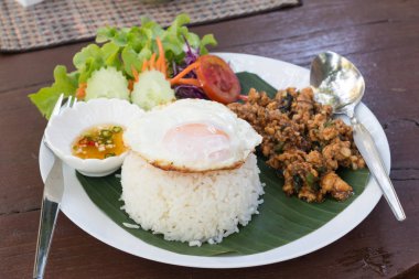 Tavada kızartılmış domuz eti ve fesleğen ve kızarmış Egg(Sunny side up ile tepesinde pirinç)