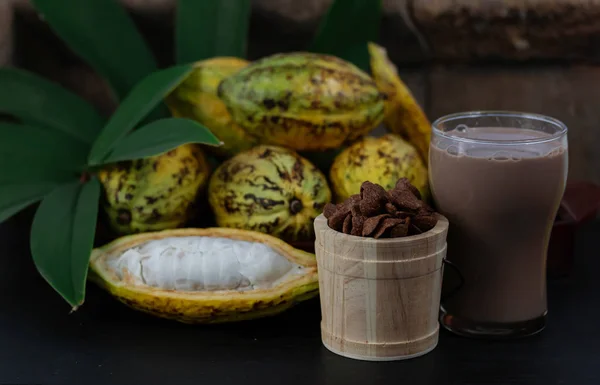 Fresh cacao fruit with cocoa crunch (Products Production from cacao) on table