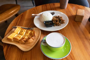 Pirinç tavada kızarmış domuz eti ve fesleğen ve süt ile Bal tost ile tepesinde