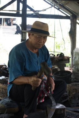 Profesyonel Demirci iş yerinde yangın ile sıcak bir metal tarafından demir hit olduğunu