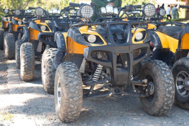 Several yellow and black ATVs are available for tourist service