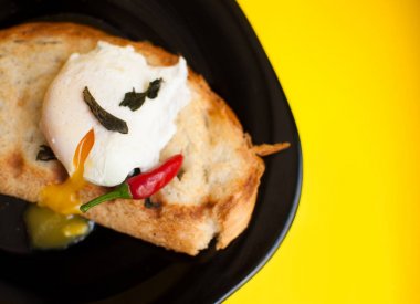 yumurta sarı bir arka plan kahvaltı üzerinde siyah bir tabak üzerinde haşlanmış