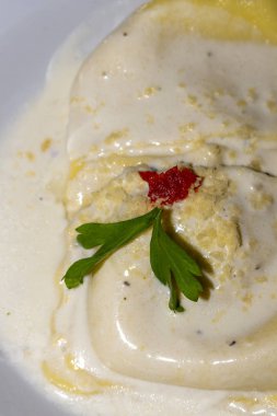 Raviolis Berchamel sos üzerine peynir ile kaplı