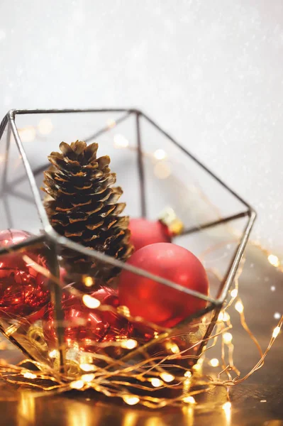 Noel süsleri, ışıklar, atmosfer. Kırmızı arka plan. Çam kozalağı. Kırmızı topları. Yeni yıl. 