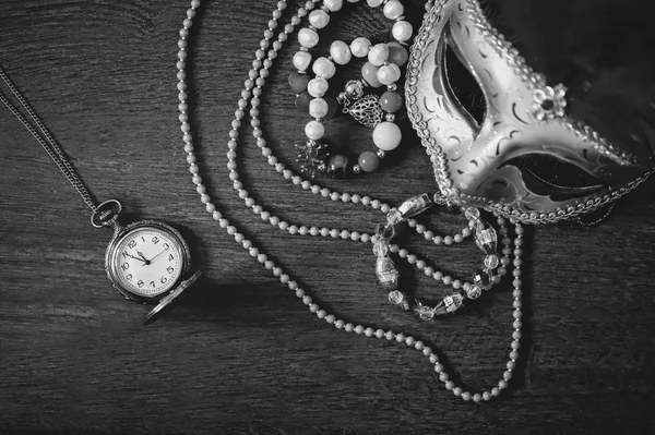 Carnival mask, jewelry, old clock. Time for party. Masquerade. Background.  Black and white