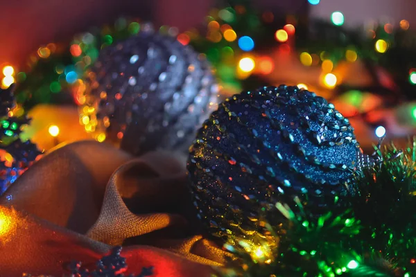 Twee blauwe bolletjes en kerstversiering in de verlichting van een slinger — Stockfoto