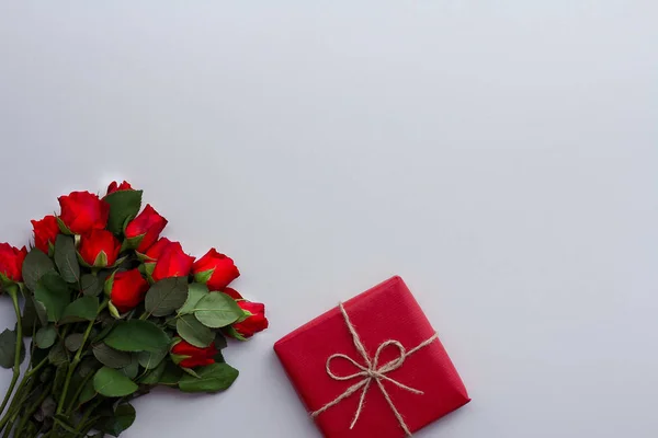 Güzel güller ve ışık arka plan üzerinde hediye kutusu
