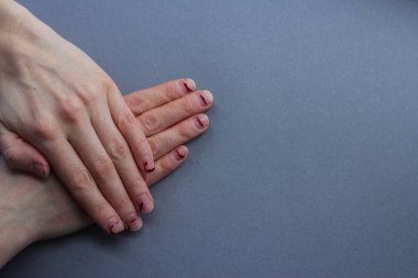 Yontma, tabakalı çivi. çivi jel Lehçe sonra. üstten bir gri background.the görünüm düzensiz ellerde