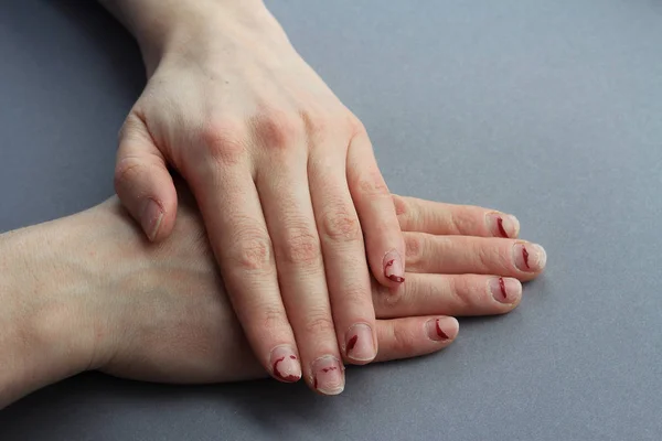 Yontma, tabakalı çivi. çivi jel Lehçe sonra. üstten bir gri background.the görünüm düzensiz ellerde