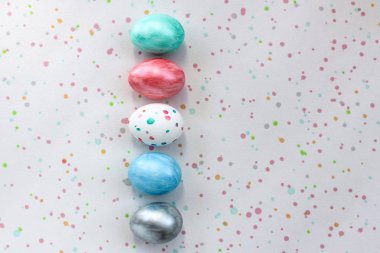 Beş renkli yumurta benekli bir arka plan üzerinde yalan. Paskalya, dekorasyon için bağımsız olarak evde yumurta boyama yaratıcı