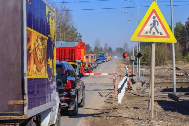 kapalı demiryolu geçişi. tren sürmek, bariyerin açılmasını bekleyen arabalar.bir semafor yanıp sönen
