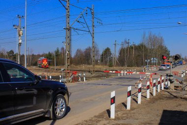 kapalı demiryolu geçişi. tren sürmek, bariyerin açılmasını bekleyen arabalar.bir semafor yanıp sönen