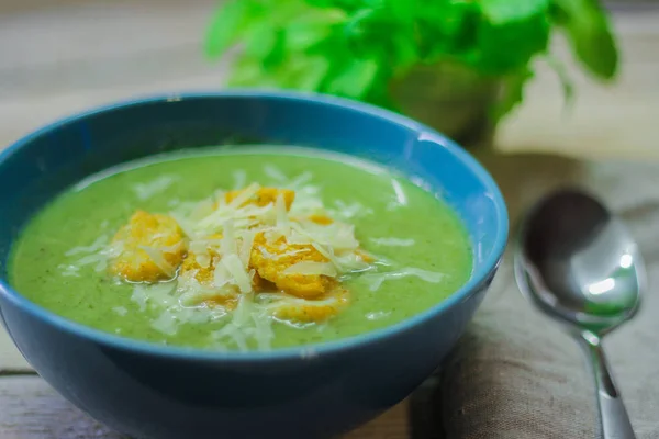 Fresh mashed soup with broccoli and green beans in a blue plate on a wooden background — Stock Photo, Image