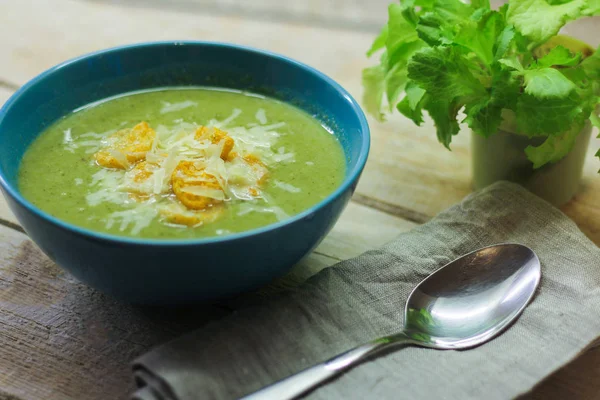 Fresh mashed soup with broccoli and green beans in a blue plate on a wooden background — Stock Photo, Image