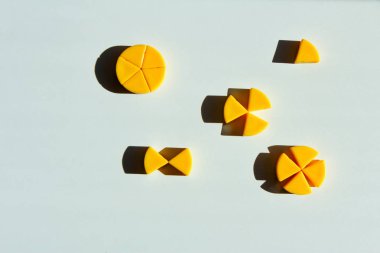 toy cheeses cut into pieces. concept of mathematical fractions and parts of one whole. clipart