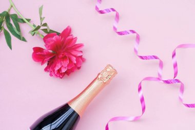 şenlikli düzen kızlar, şampanya bir şişe, kozmetik, pembe bir arka plan üzerinde kırmızı çiçek şakayık. metin için yer