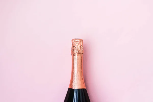 pembe arka plan üzerinde köpüklü şarap şişesi. tatil kutlamak için şampanya kapalı şişe