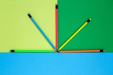 Beş kalem Neon renkleri bir fan gibi renkli bir arka planda yalan.