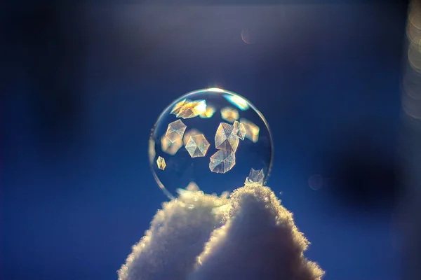 Boule de savon congelée sur neige au coucher du soleil, formation de cristaux — Photo