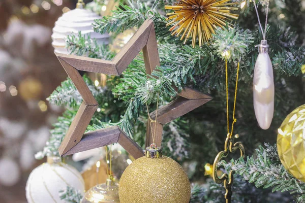 Weihnachtsspielzeug Holzstern auf dem Ast des Weihnachtsbaums. — Stockfoto