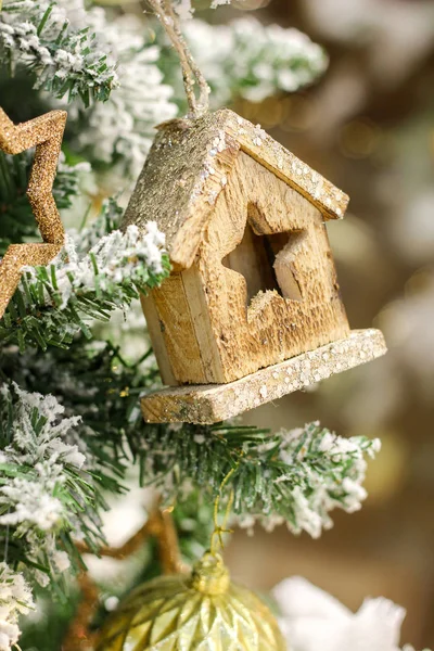 Christmas card. wooden toy house hanging on a branch of spruce. — Stock Photo, Image