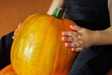 Çocukların elinde büyük bir portakal kabağı. balkabağı festivali