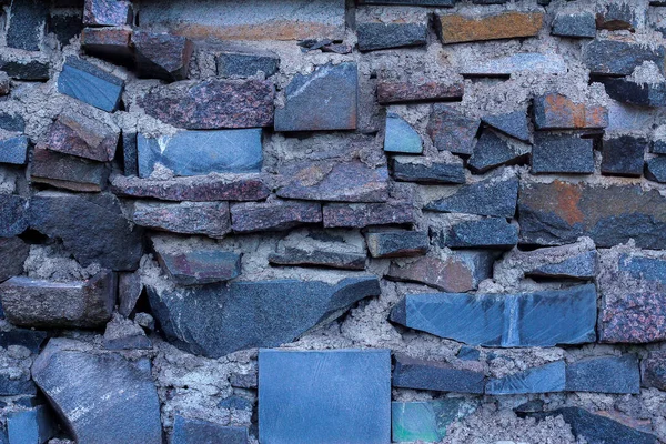 a wall of broken granite and marble. stone background, space for text.