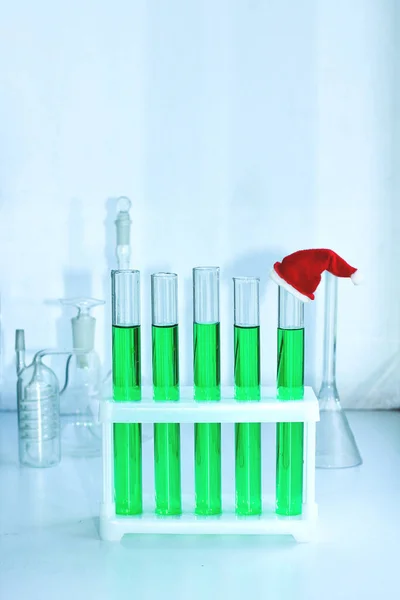 Cinco viales de solución verde en un laboratorio químico. en el tubo final es un casquillo rojo decorativo en miniatura — Foto de Stock