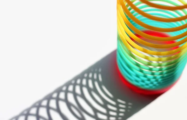 Beyaz arkaplanda gökkuşağı renkli tel spiral.