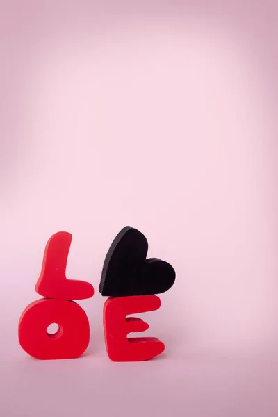 Love word. Love composition on pink background