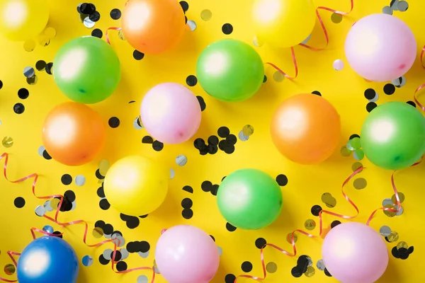Kolorowe Balony Konfetti Żółty Blat Zobacz Tło Uroczysty Lub Strony — Zdjęcie stockowe