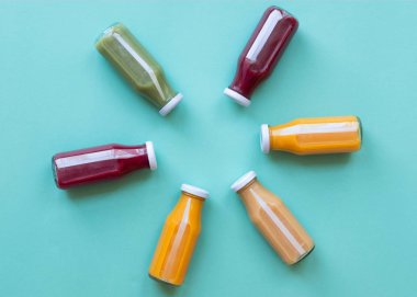 Meyve ve sebze suyu şişeleri mavi arka plan izole. Sağlıklı konsept