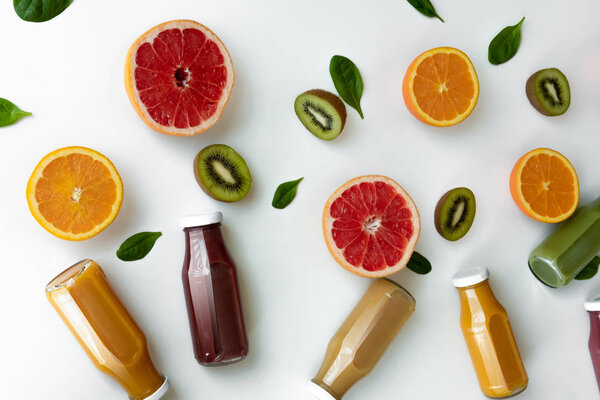 Апельсины, грейпфруты и соки на белом фоне. Здоровое понятие
