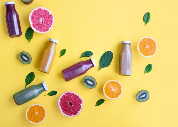 Различные соки и фрукты на желтом фоне. Здоровый и свежий концепт
.