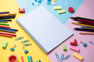 Kopya alanı ile renkli arka plan üzerinde okul malzemeleri ile Defter
