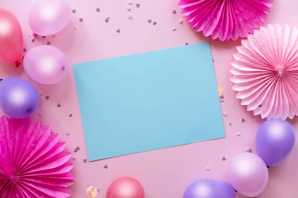 カラフルな風船と紙吹雪は テキストの中央に青い紙とピンクのテーブルの上に 誕生日 休日やパーティーの背景 ロイヤリティフリーのストック画像