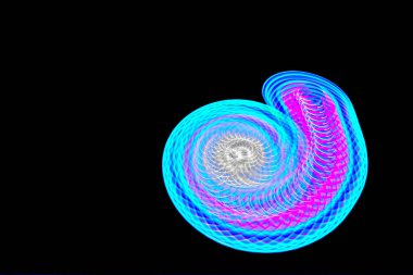 Siyah arkaplan ile dönen bir ışığın uzun pozlama fotoğrafı.