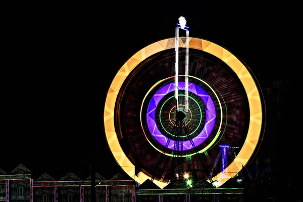 夜に回転する楽しい公正なジャイアントフェリスホイール 夜の回転巨人ホイールの遅いシャッター写真 — ストック写真