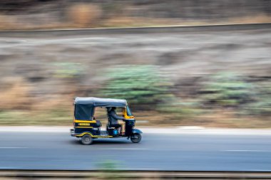 Shindawane, Pune, Hindistan: 16 Ocak 2016 - Uzun bir tren mavi gökyüzünün açık bir zemininde bulutlu bir tünelden çıkıyor.