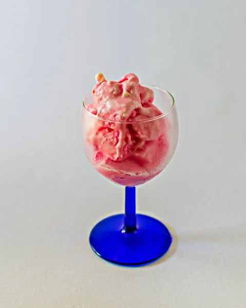 透明感のある白を基調としたワイングラスにピンクの苺アイスの美味しさが閉じ込められたイメージ — ストック写真