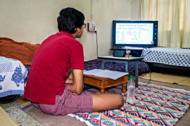 Pune, Hindistan - 2 Haziran 2020: Pune, Maharashtra, Hindistan 'da yaygın COVID-19, Corona virüsü nedeniyle kapalı okullar nedeniyle cep telefonuyla çevrimiçi eğitim alan öğrenci.