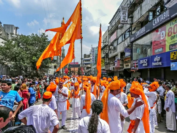 2010年9月22日インド マハラシュトラ州プネー 伝統的な巨大なオレンジ色の旗を持つ若者のグループが ガナパティ行進中に集合的に行進する — ストック写真