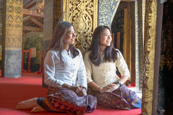 pretty twin Thai lady in temple smile and happy