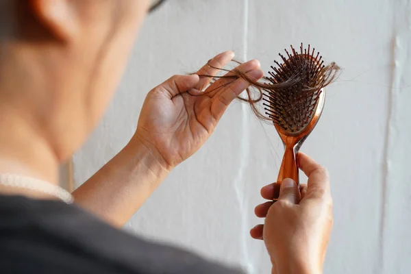 Saç fırçasında uzun saçlı kadınlar saç dökülme problemleri yaşar.. — Stok fotoğraf