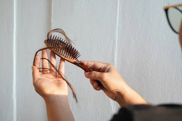 Women with long hair on the hair brush show hair loss problems. — Stock Photo, Image