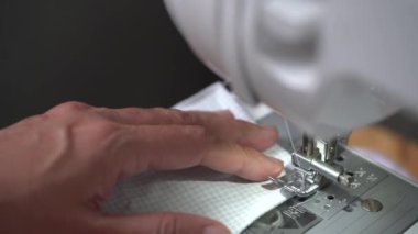 Kadın el yapımı el işi projeleri maske takıyor. Corona virüsü koruması için ev yapımı tıbbi maske. Evde Covid-19 yüz maskesi dikiyorum..