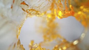 Işık Arkaplanı 'ndaki Altın Sıvı Akımı' nın Süper Yavaş Çekimi. Yüksek Hız Sinema Kamerası, 4K.