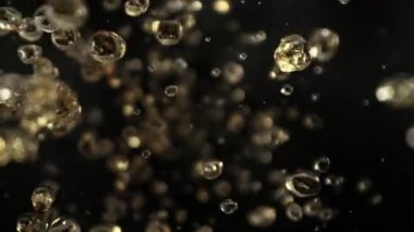Uçan Altın Sıvı Düşürmenin Süper Yavaş Çekimi Kara Arkaplan 'da Kameraya doğru 1000fps' de. Yüksek Hız Sinema Kamerası, 4K.