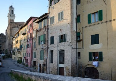 arka planda Torre del Mangia ile Siena ortaçağ kasabasının tarihi merkezinde tipik sokak manzarası